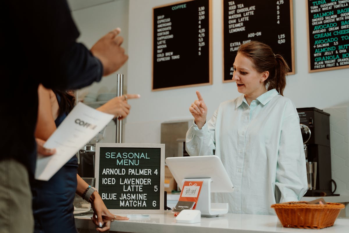 Busy cafe counter with seasonal menu and modern POS register — small business growth in action